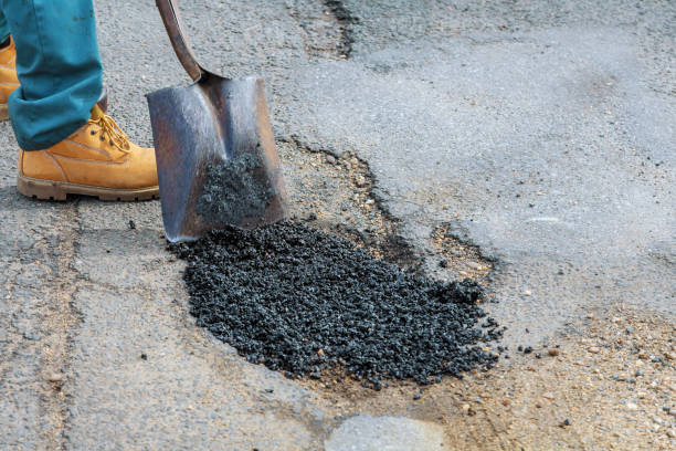 Laying new asphalt, covering the pit, hole in asphalt with very bad quality road