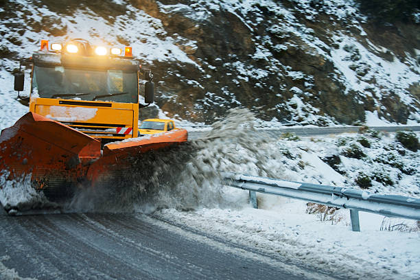 Snow plough moving snow on a dangerous bend after a snow storm.